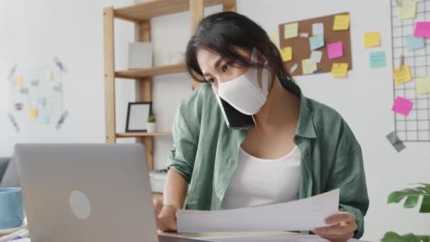 아시아 여성들은 거실에 책상에 사이트를 스마트폰 쇼핑을 이용해 마스크를 집에서 — 비디오