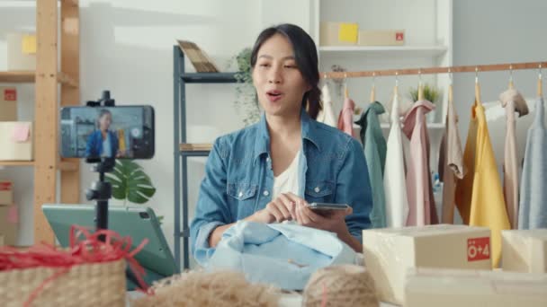 아시아 디자이너는 휴대폰 주문을 사용하고 가게에서 온라인 스트리밍을 녹화하는 보여준다 — 비디오