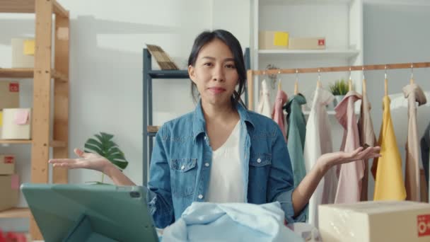 若いアジアの女性ファッションデザイナーは 携帯電話を使用して購入注文を受け 店でライブストリーミングビデオをオンラインで録画した服を示しています 中小企業の所有者 オンライン市場の配信の概念 — ストック動画