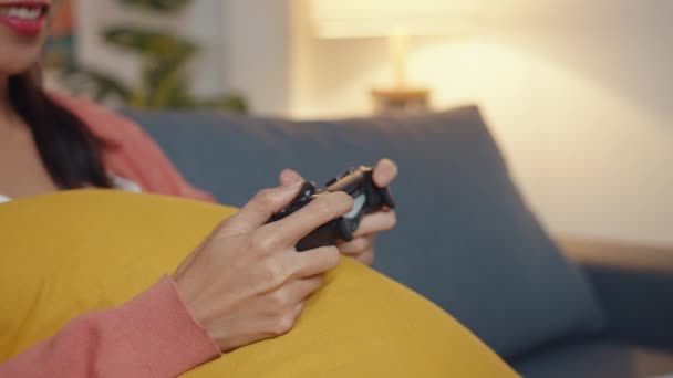 아시아의 여성은 컨트롤러를 사용하여 비디오 게임을 합니다 거실에서 순간을 보내고 — 비디오