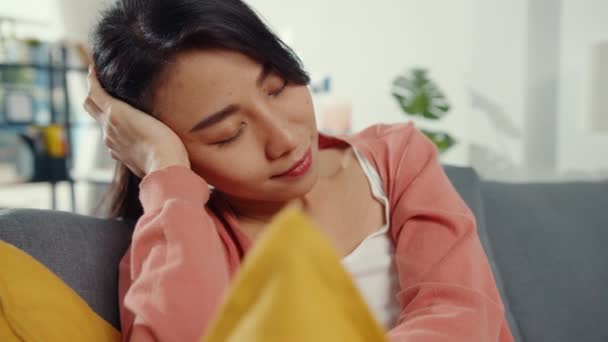 아름다운 아시아 여인은 거실에 베개를 소파에 휴식을 취한다 직장에서 휴식을 — 비디오