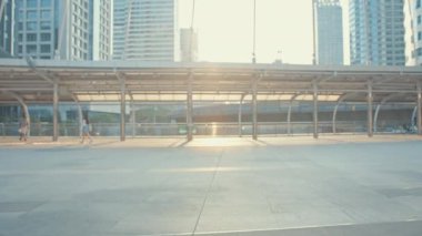 Asyalı iş kadını işe gider, işe gider, gülümser, sırt çantası takar, bisiklet sürer, şehir caddesinde bir bina inşa eder. Bisiklet yolculuğu, bisikletle yolculuk, iş seyahati konsepti..