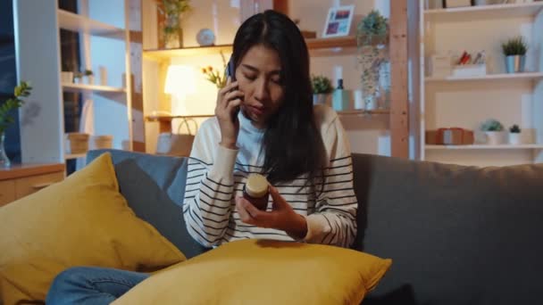 Chora Młoda Azjatka Trzymać Lekarstwa Siedzieć Kanapie Używać Smartfona Konsultacji — Wideo stockowe