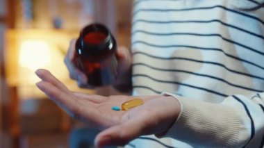 Hap tutan hasta Asyalı genç bayan. İlaca bak. Evdeki kanepede otur. Doktor siparişi üzerine ilaç alan bir kız, evde karantina, Coronavirus sosyal uzaklık sağlık konsepti..