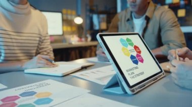 Asya 'daki iş adamlarının planlama istatistikleri, beyin fırtınası ve tablet grafik çizelgesini tutan ekibin başlığıyla buluşması ve çalışanlar not alsın. Finans stratejisi istatistik başarı kavramı.