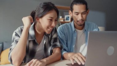 Başarı Asya 'lı genç çift ve kadın heyecan verici Maready Bank kredi anlaşması evde dizüstü bilgisayarda yeni ev için, mutlu karı ve koca finans yatırımından memnun.