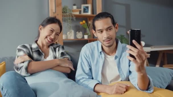 Ευτυχισμένο Νεαρό Ζευγάρι Ασία Άνδρας Και Γυναίκα Κάθονται Καναπέ Χρήση — Αρχείο Βίντεο