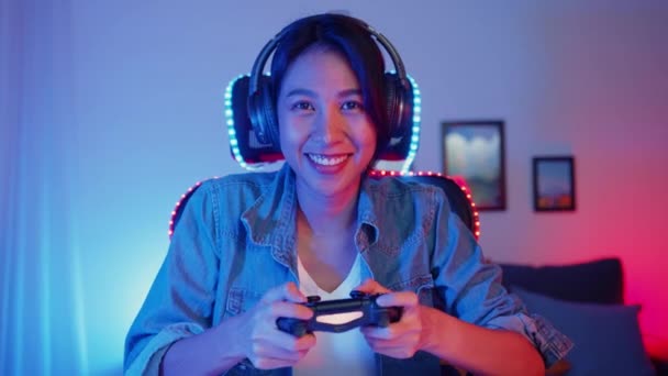 Happy asia girl gamer wear headphone competition play video game online  with smartphone. Stock Photo by Tirachard