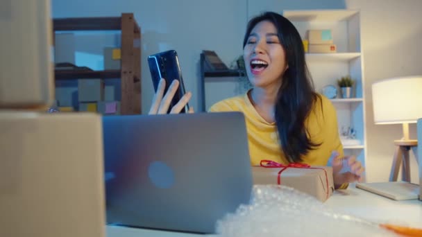 Молодая Азиатская Предпринимательница Используя Смартфон Получает Заказ Покупку Показывает Упаковку — стоковое видео