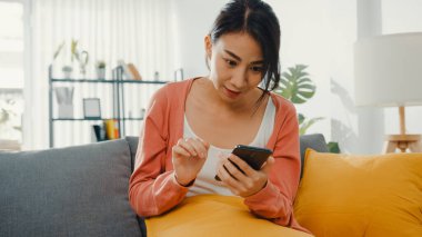 Güzel bir bayan, sabah evdeki oturma odasındaki kanepede oturan bir çiftle akıllı telefon konuşması yapıyor. Evde kal, covid, nomofobi, online alışveriş, sosyal ağ bağımlılığı konsepti için karantina.