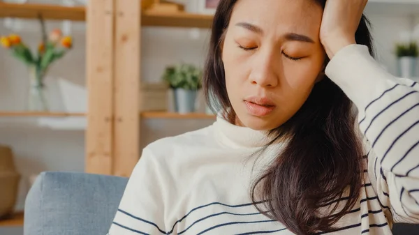 생각깊은 아시아 여성은 소파에서 무릎을 거실에 바라볼 때외롭고 우울증에 소녀는 — 스톡 사진