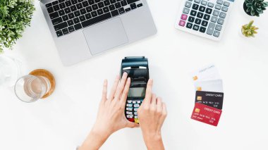 Asya 'lı kadının bilgisayarını kredi kartıyla online alışveriş yaparken en iyi görüntüsü. Faturayı evdeki oturma odasındaki masada ödeme terminaliyle öde. Evden çalışmak, sosyal uzaklık, koronavirüs için karantina.