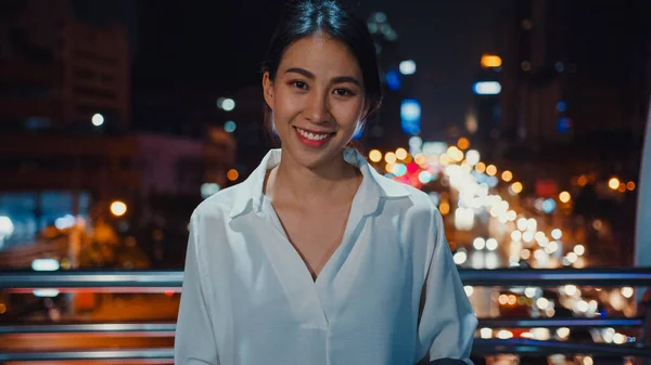 ファッションオフィスの服を着た若いアジアの実業家が笑顔でカメラを見て成功し 夜には都会の近代的な都市で屋外に立って幸せです 外出先でのビジネスと通勤コンセプト — ストック写真