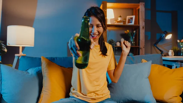 カメラを見て幸せな若いアジアの女性は自宅のリビングルームでオンラインビデオ通話を介して友人トーストドリンクビールと夜のパーティーイベントをオンラインで楽しむ 自宅隔離に滞在 社会的距離の概念 — ストック写真