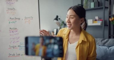 Genç Asyalı bayan öğretmen video konferansı web kamerasından akıllı telefon konuşmasından arıyor evde online sohbette öğretmeyi öğrenin. Uzak okul sınıfı, sosyal uzaklık, korona virüsünün önlenmesi için karantina.