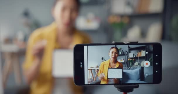 若いアジア女性教師ビデオ通話ウェブカメラでスマートフォンの話を自宅でオンラインチャットで教えることを学ぶ 遠隔授業 社会的距離 コロナウイルス防止のための隔離 画面を閉じる — ストック動画