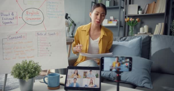 若いアジア女性英語教師ビデオ会議は 自宅でオンラインチャットでウェブカメラの学習教師によるスマートフォンの話を呼び出します 遠隔教室 社会的距離 コロナウイルス対策隔離 — ストック動画