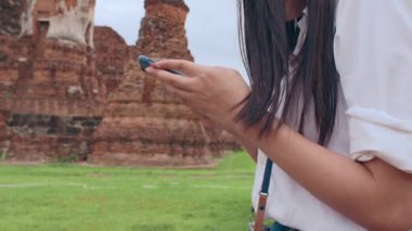 Neşeli, güzel, Asyalı, genç, sırt çantalı, günlük blog yazarı, fotoğraf makineli, akıllı telefonlu, gülümseyen, mutlu yüzlü, eski şehir, Lifestyle Turist Tatil Konsepti 'nde seyahat eden bir kadın..