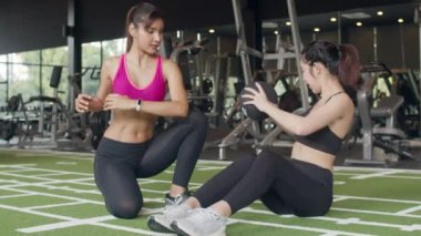Asyalı bayan kişisel antrenör vücut ağırlığı eğitimine fitness topuyla bayan müşteriye, spor salonunda antrenman yapan insanlar fitness, spor ve sağlıklı yaşam tarzı konseptine odaklan..