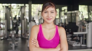 Spor kıyafetli mutlu Asyalı spor kadın antrenörü kameraya bakıp neşeli ve dinç hissediyor spor salonunda antrenman yapan insanlar spor, spor ve sağlıklı yaşam tarzı kavramında kullanılıyor..