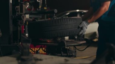 Tamir istasyonunda araba lastiği değiştiren profesyonel bir tamirci. Atölye gecesinde tekerlek hizalama işi. Araba tamir eden Asyalı yetenekli bir adam. Araba servisi onarımı.