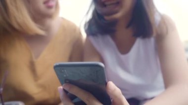 Yakın arkadaş canlısı genç Asyalı turist akıllı telefonlardan keyif alıyor. Sosyal medyada, Cafe City 'deki liman nehrinin önünde fotoğraf paylaşımı, Lifestyle Turist Tatil Konsepti.