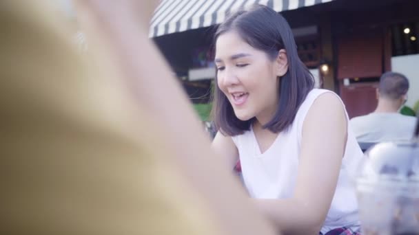 若いアジアの女性が近くの友人の観光客とカジュアルな楽しみとスマートフォンの共有写真でオンラインソーシャルメディアビューポート川の前のカフェ街で ライフスタイル観光旅行休日のコンセプト — ストック動画