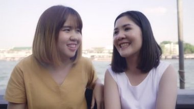 Genç Asyalı yakın arkadaş turist dedikodu yapmaktan zevk alıyor. Nehirdeki liman botunun önünde sohbet ediyorlar. Cafe City 'de keyifli yolculuklar, turist seyahati konsepti..