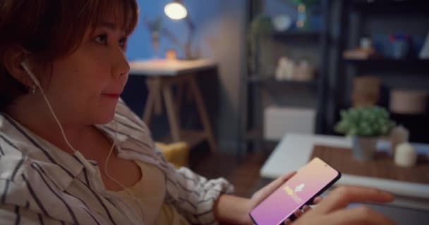 Jonge Aantrekkelijke Asia Dame Dragen Koptelefoon Met Behulp Van Telefoon — Stockvideo