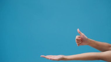 Genç kız eli boş alanda stüdyoda mavi arka planda inanılmaz bir şey gösteriyor. Yer için bir metin, reklam için bir mesaj kopyala. Reklam alanı, tanıtım içeriğini düzenle.