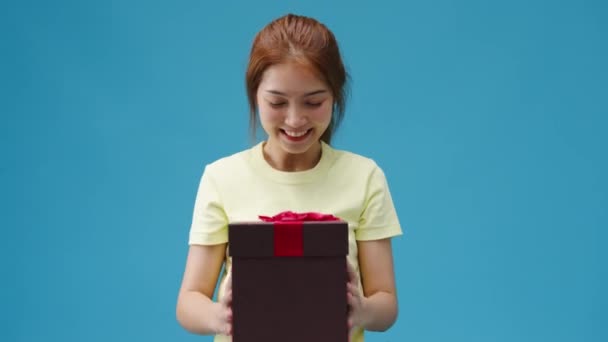 Дівчинка Азії Посміхається Тримає Відкриту Коробку Ізольовану Над Синім Фоном — стокове відео