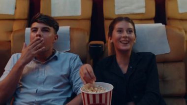 Çekici, neşeli, beyaz bir çift sinemada film izlerken gülüyor. Yaşam tarzı eğlence konsepti.