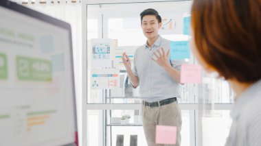 Asyalı iş adamlarıyla beyin fırtınası toplantıları iş sunumu fikirleri, iş arkadaşları projeleri ve yeni normal ofiste koruyucu yüz maskesi takıyorlar. Corona virüsünden sonra yaşam tarzı ve çalışma.