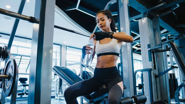 Beautiful young Asia lady exercise drinking water after fat burning workout in fitness class. Athlete with six pack, Sportswoman recreational activity, functional training, healthy lifestyle concept.