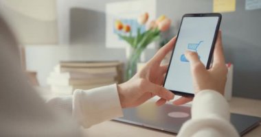 Genç Asyalı bayan cep telefonu siparişini online alışveriş ürünü olarak kullanıyor ve işlemleri başarılı olan bankacılık uygulaması ile faturaları ödüyor. Evde kal, karantina aktivitesi, koronavirüsü önlemek için eğlenceli aktivite..