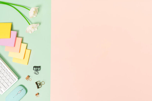 Минимальное рабочее пространство - Креативная плоская фотография рабочего стола. Вид сверху офисный стол с клавиатурой, мышью и клейкой запиской на зеленом фоне розового цвета. Вид сверху с фотографией пространства для копирования.