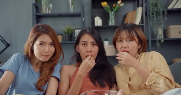魅力的なアジアの素敵な女性の女の子のグループはショックを叫び 恐怖の瞬間は自宅のリビングルームでソファの上にポップコーンはホラーオンライン映画エンターテイメントを見て食べる 週末のライフスタイル活動隔離コンセプト — ストック動画