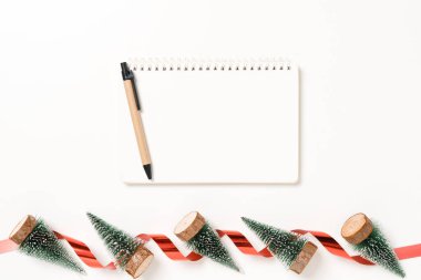 Kış, geleneksel Noel kompozisyonu ve yeni yıl tatili sezonunun en az yaratıcı düzlüğü. Üst görünüm beyaz arkaplandaki metin için siyah defteri aç. Model yap ve uzay fotoğrafçılığını kopyala.