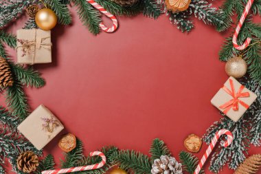 Geleneksel Noel kompozisyonu ve yeni yıl tatili sezonunun en az yaratıcı düzlüğü. Kırmızı arka planda kışın en iyi manzaralı Noel süslemeleri ve mesaj için boş alan. Boşluk fotoğrafçılığını kopyala.