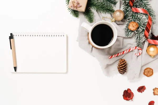 Kış, geleneksel Noel kompozisyonu ve yeni yıl tatili sezonunun en az yaratıcı düzlüğü. Üst görünüm beyaz arkaplandaki metin için siyah defteri aç. Model yap ve uzay fotoğrafçılığını kopyala.