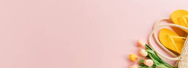 Creative flat lay of travel vacation spring or summer tropical fashion. Top view beach accessories on pastel pink color background. Panoramic banner with copy space for text and Advertising area.