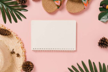 Creative flat lay of travel vacation spring or summer tropical fashion. Top view beach accessories open mockup black notebook for text on pastel background. Top view mock up copy space photography.
