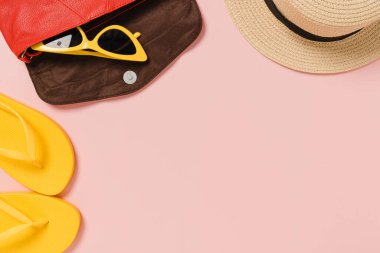 Creative flat lay photo of travel vacation spring or summer tropical fashion. Top view beach accessories on pastel pink color background with blank space for text. Top view copy space photography.