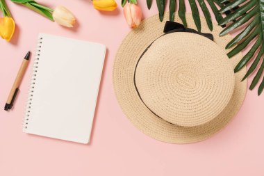 Creative flat lay of travel vacation spring or summer tropical fashion. Top view beach accessories open mockup black notebook for text on pastel background. Top view mock up copy space photography.