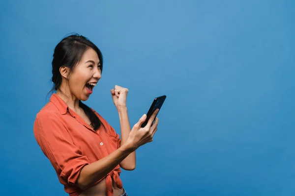 Overrasket Ung Asiatisk Dame Som Bruker Mobiltelefon Med Positivt Uttrykk – stockfoto