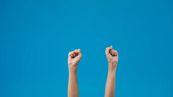 Young woman showing hand palm clenched fist and knock isolated over blue background in studio. Copy space for place a text, message for advertisement. Advertising area, mock up promotional content.