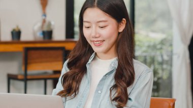 Kahvecide dizüstü bilgisayarla çalışan neşeli Asyalı serbest bayan. Çekici Japon iş kadını şehir kafesinde ya da restoranda rahatlar..