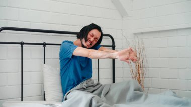 Genç Asyalı bir adam sabah uyanır, erkek uyandıktan sonra yatak odasında gerinir. Yakışıklı erkekler uyur, uyur. Modern ev konseptinde rahatlarlar..