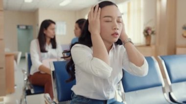 Bekleme odasında oturan genç Asyalı kız kötü haberlerden korkuyor. Stres, babası için hastane odasının önünde üzüntü, hastane çevresi konsepti..