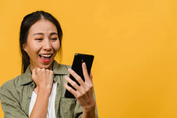 Yllättynyt Nuori Aasian Nainen Joka Käyttää Matkapuhelinta Positiivisella Ilmeellä Hymyilee — kuvapankkivalokuva